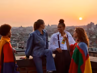 Friends on a rooftop at sunset with cinematic backward camera movement.