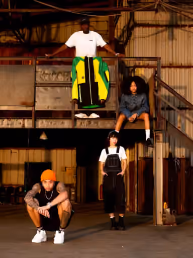 Warehouse fashion group portrait with gritty industrial atmosphere.